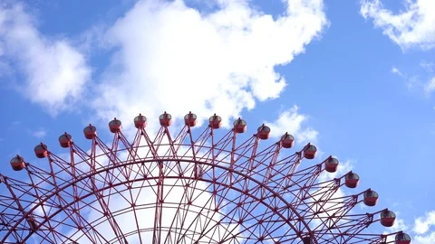 Big red ferris wheel over cloud moving on blue sky Stock Footage 99522270