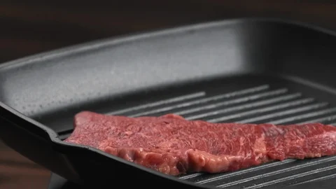 Big red raw chunk of tasty beef or mutton throwing on a heat grill skillet Stock Footage 123571682