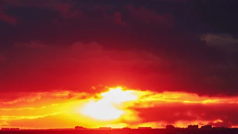 Big red sun over the roofs of city buildings, evening sunset. Timelapse of a clo Stock Footage 220721403