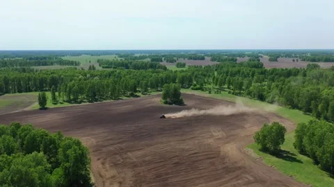 A big red tractor plows the soil Stock Footage 131187509