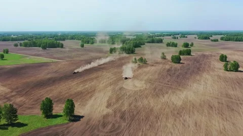 A big red tractors plows the soil Stock Footage 130795745