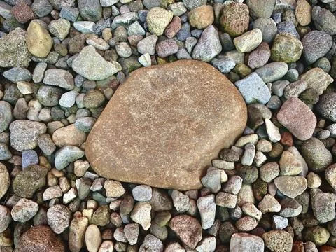 Big reddish stone between the small stones Stock Photos