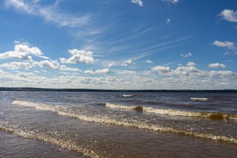 A big river flows under big clouds. Stock Photos