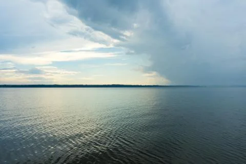 A big river flows under big clouds. Stock Photos