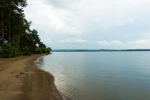 A big river flows under big clouds. Stock Photos