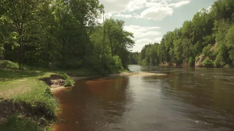 Big river in forest with cliffs at the banks and water flowing in circles Stock Footage 159981328