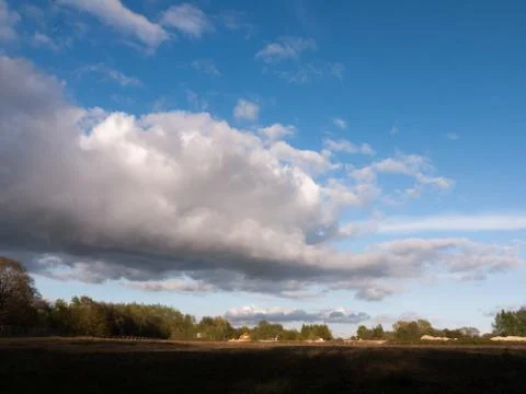 A big rolling cloud of white over a landscape shot of farmland with open sp.. Stock Photos