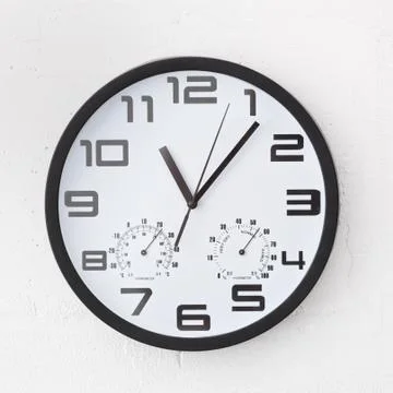 Big round clock on white wall. Stock-Fotos