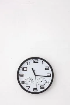 Big round clock on white wall. Stock Photos