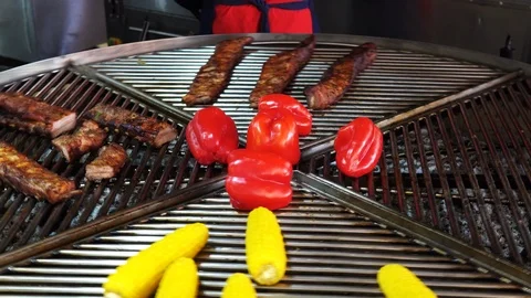 Big round rotating grill with meat and vegetables on it on street food market Stock Footage 120016464