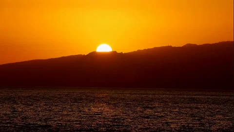 A big round sun sets behind the mountains Stock Footage 337427448