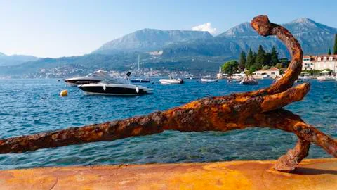 Big rusty ship anchor in front of a small marina of the village of Rose - Rose Foto stock