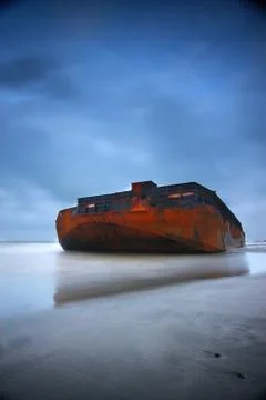 A big rusty ship on a beach Stock Photos