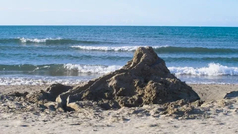 A big sand castle in front of the rolling sea 2 Stock Footage 307086014