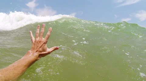 Big sea wave covers a swimmer at a beach 스톡 동영상 24985352