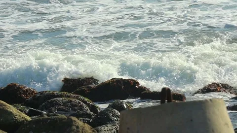 Big sea waves hit the rocks by the beach Stock Footage 152520115