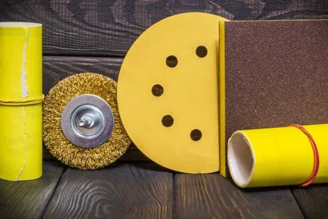 Big set of abrasive tools and yellow sandpaper on black wooden boards Stock Photos