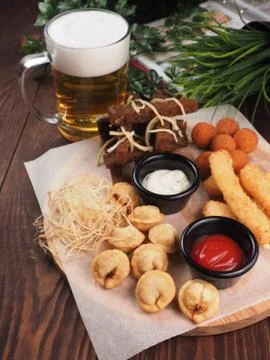 Big set of snacks for beer it includes fried cheese balls, pigtail cheese, fr Stock Photos