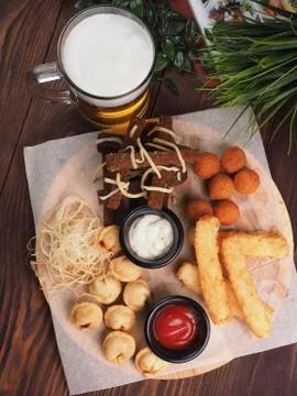 Big set of snacks for beer it includes fried cheese balls, pigtail cheese, fr Stock Photos