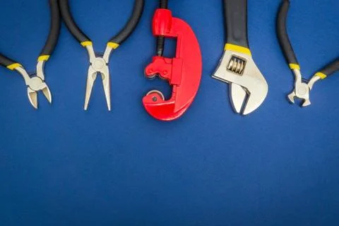 Big set of tools and red pipe cutter on blue background prepared by the maste Stock Photos