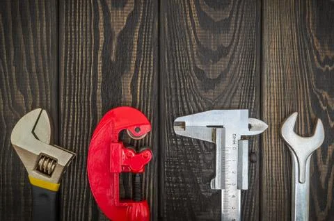 Big set of tools for plumber on black wooden boards prepared by professional Stock Photos