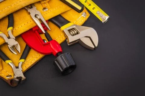 Big set of tools in suede bag on black background prepared by the master before Stock Photos