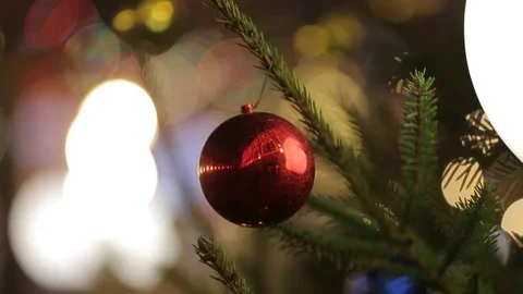 Big shiny red ball hanging on a Christmas tree in the background . Close-up Stock Footage 84042846