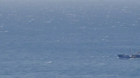 Big ship passing by on big ocean waves in the distance Stock Footage 238538447
