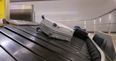 Big silver suitcase slips down to baggage conveyor, slow motion Stock Footage 292920585