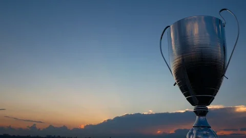 Big silver winner trophy cup on the black clouds background with sunset lines Stock Footage 76968853