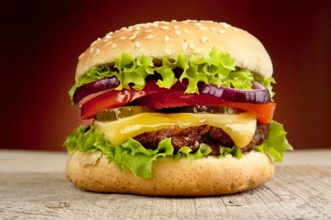 Big single cheeseburger isolated on red background Stock Photos