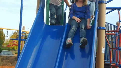 Big sister slides down the slide Stock Footage 58637228