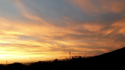 Big sky sunset orange clouds, electricity lines pan to rail crossing road sign Stock Footage 106731732