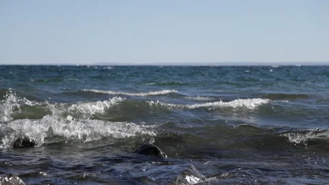 Big slow motion waves rolling into rocky shore in early evening, Lake Super.. Stock Footage 307951839