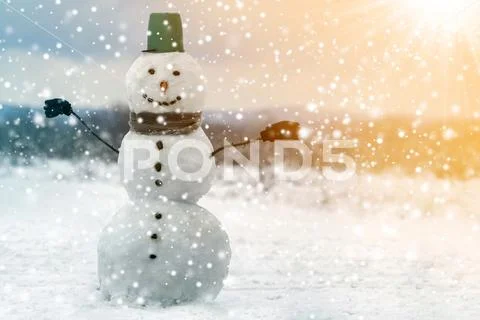 Big smiling snowman with bucket hat, scarf and gloves on white snowy field wi Stock Photos