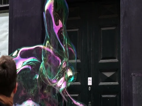 Big soap bubble being made and floating in the air then explode in slow motion Stock Footage 75887740
