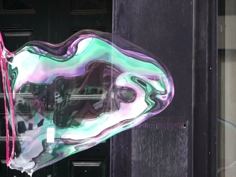 Big soap bubble being made and floating in the air then explode in slow motion Stock Footage 75887897