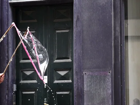 Big soap bubble being made and floating in the air then explode in slow motion Stock Footage 75888322