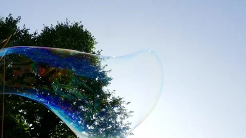 Big soap bubble being made and floating in the air then explode in slow motion Stock Footage 144419574
