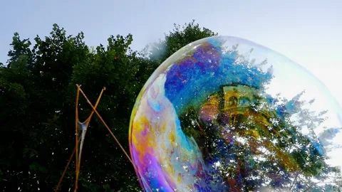 Big soap bubble being made and floating in the air then explode in slow motion Stock Footage 144419605