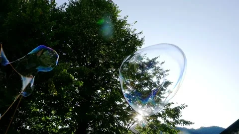 Big soap bubble being made and floating in the air then explode in slow motion Stock Footage 144419630