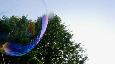 Big soap bubble being made and floating in the air then explode in slow motion Stock Footage 144419667