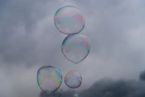 Big soap bubbles against the background of cloudy sky. Stock Photos