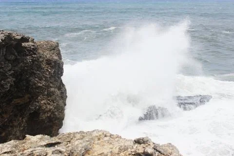 Big splash in the ocean against rock Stock Photos