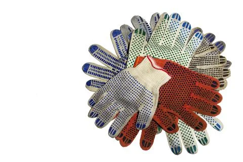 Big stack of knitted protective gloves with colored dots on working sides a.. Stock Photos