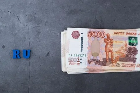 Big stack of Russian money banknotes of five thousand rubles lying on a grey Stock Photos