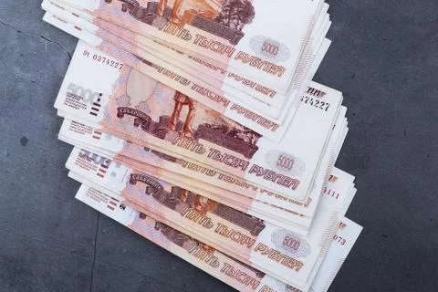 Big stack of Russian money banknotes of five thousand rubles lying on a grey Stock Photos