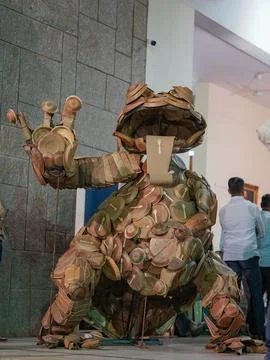 A big statue of frog which is made by plates and bowls of dry leaves Stock Photos