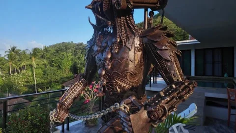 Big statue of movie predator made of metal in hotel complex, in the Видео 269504140