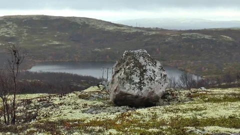 A big stone on the background of the lake in the mountain tundra. Stock Footage 69076897